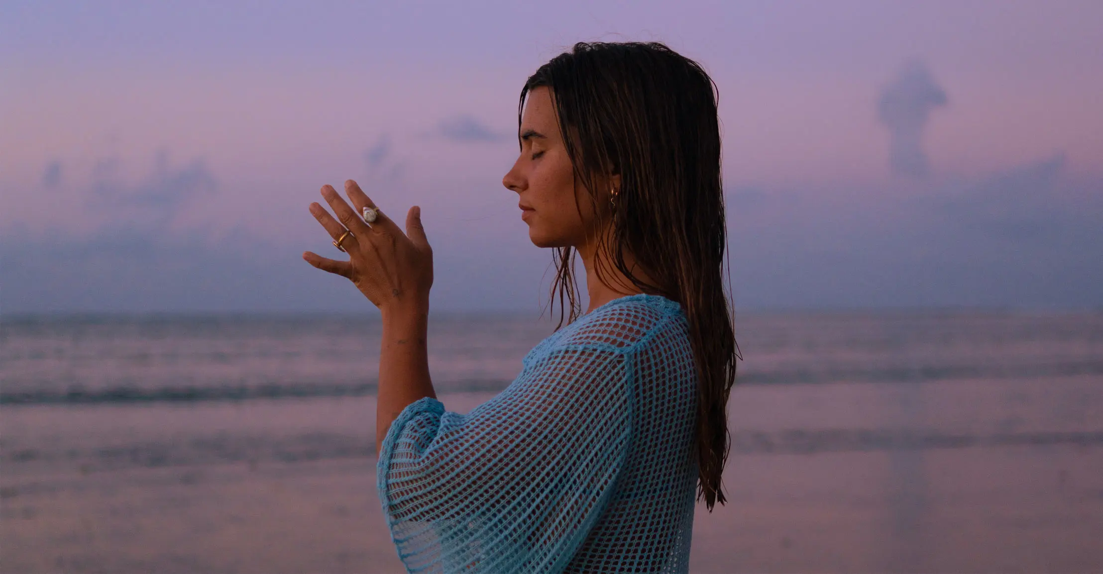 Ari in prayer at the sea at dusk