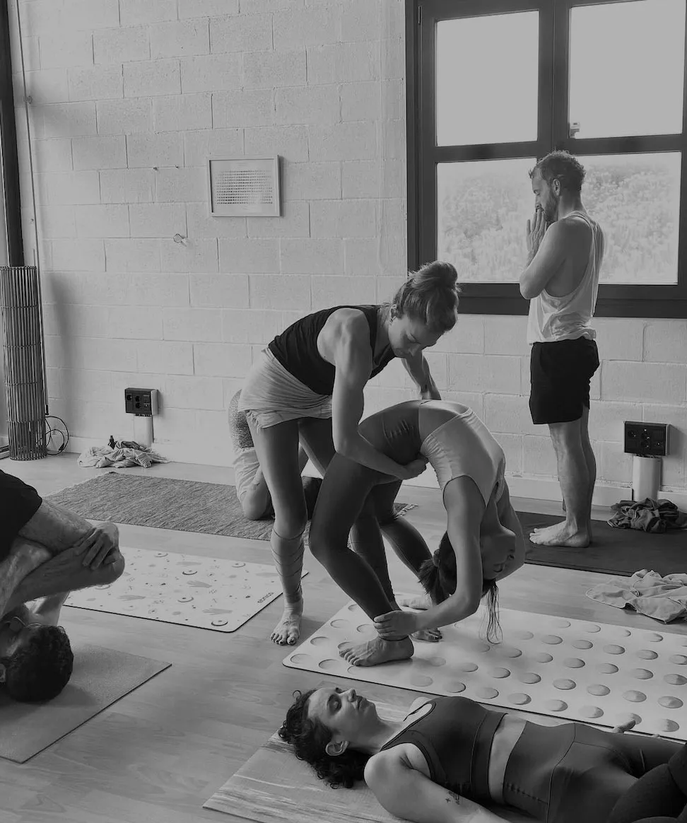 Ari assisting a student in a yoga class