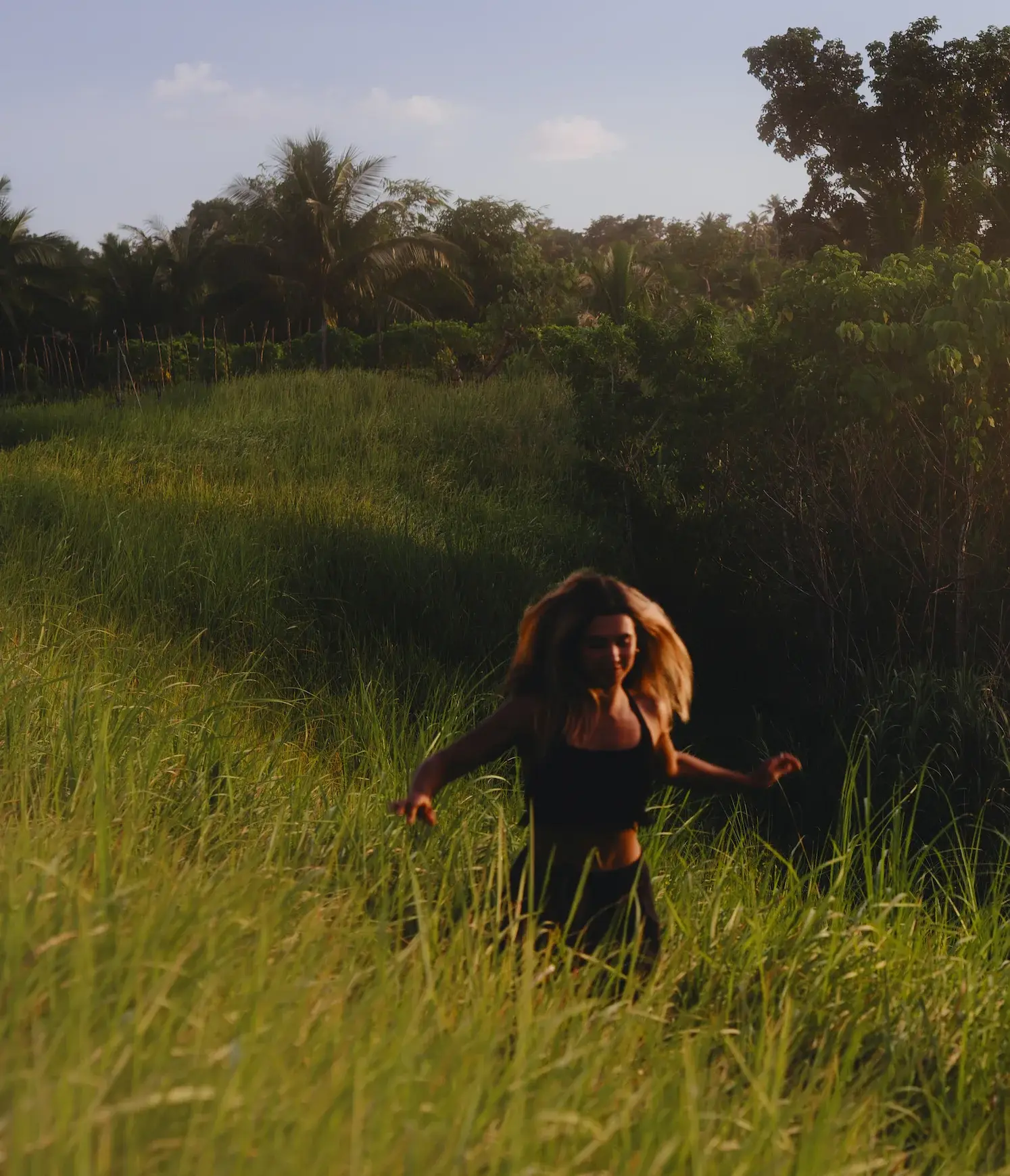 Ari running joyfully through tall golden-hour grass